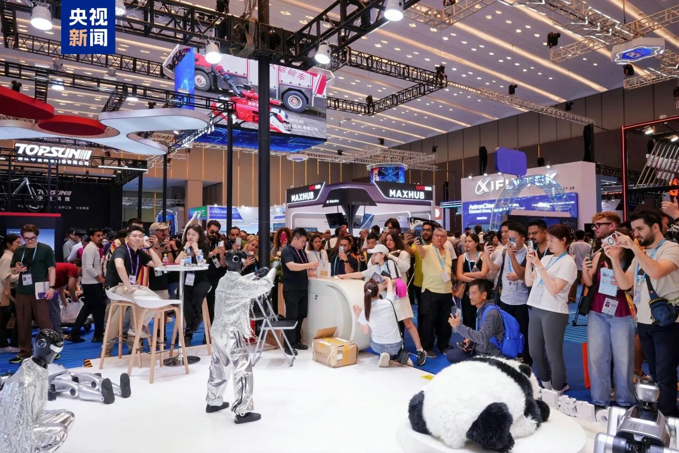 A humanoid robot performing in front of a crowd at a trade show.