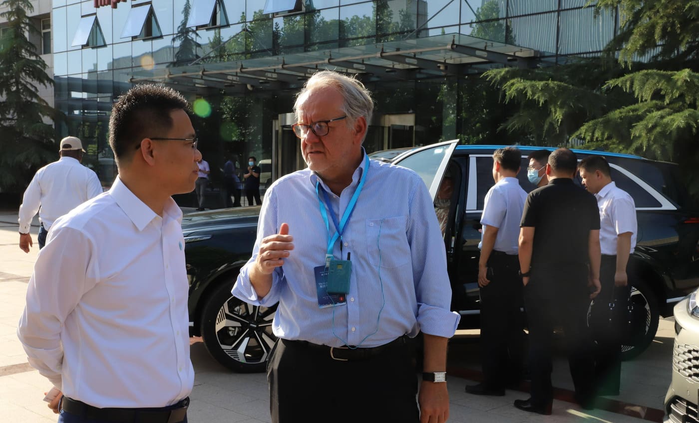 A buyer and a factory representative talking outside the company office building on arrival.