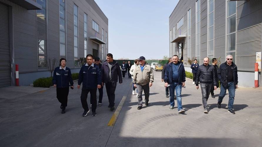 Two visitors walking out of an assembly hall at the end of a factory visit.