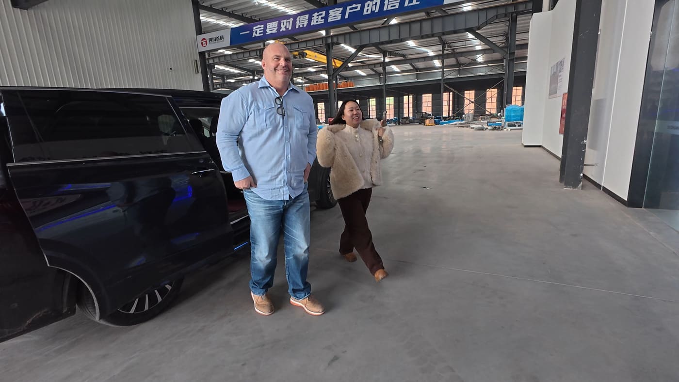 A group of buyers walking through a factory yard between workshop buildings with the host team.